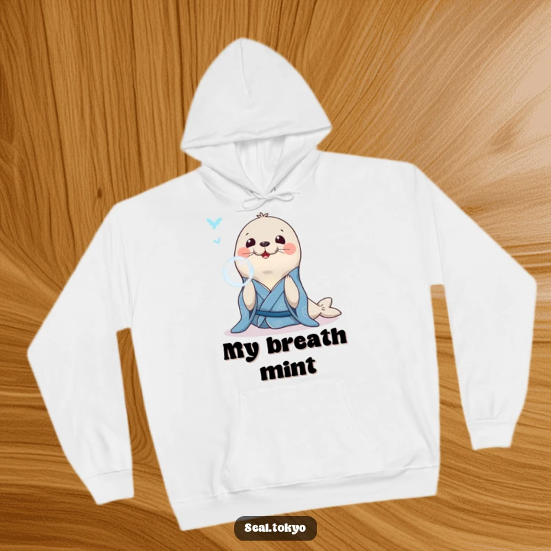 Funny Seal Hoodie: A smiling seal in a blue kimono, gracefully blowing a bubble ring, perfect for relaxation.